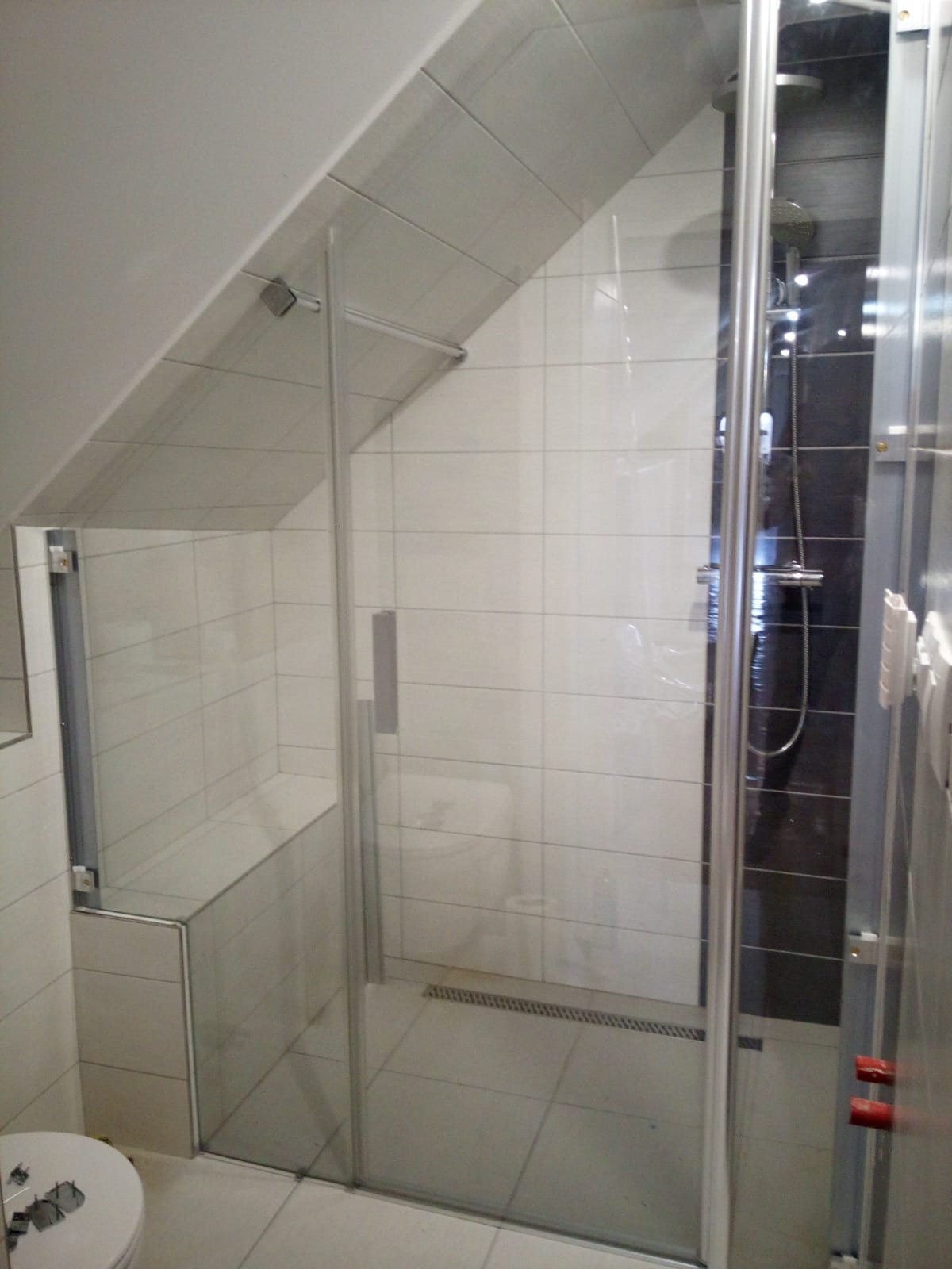 Zkosené sprchové dveře s ořezem skla na výklenek v průběhu instalace - bez nasazených krycích profilů